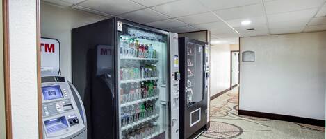 A hallway with vending machines and a carpeted floor.