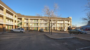 A multi-story building with a parking lot in front.
