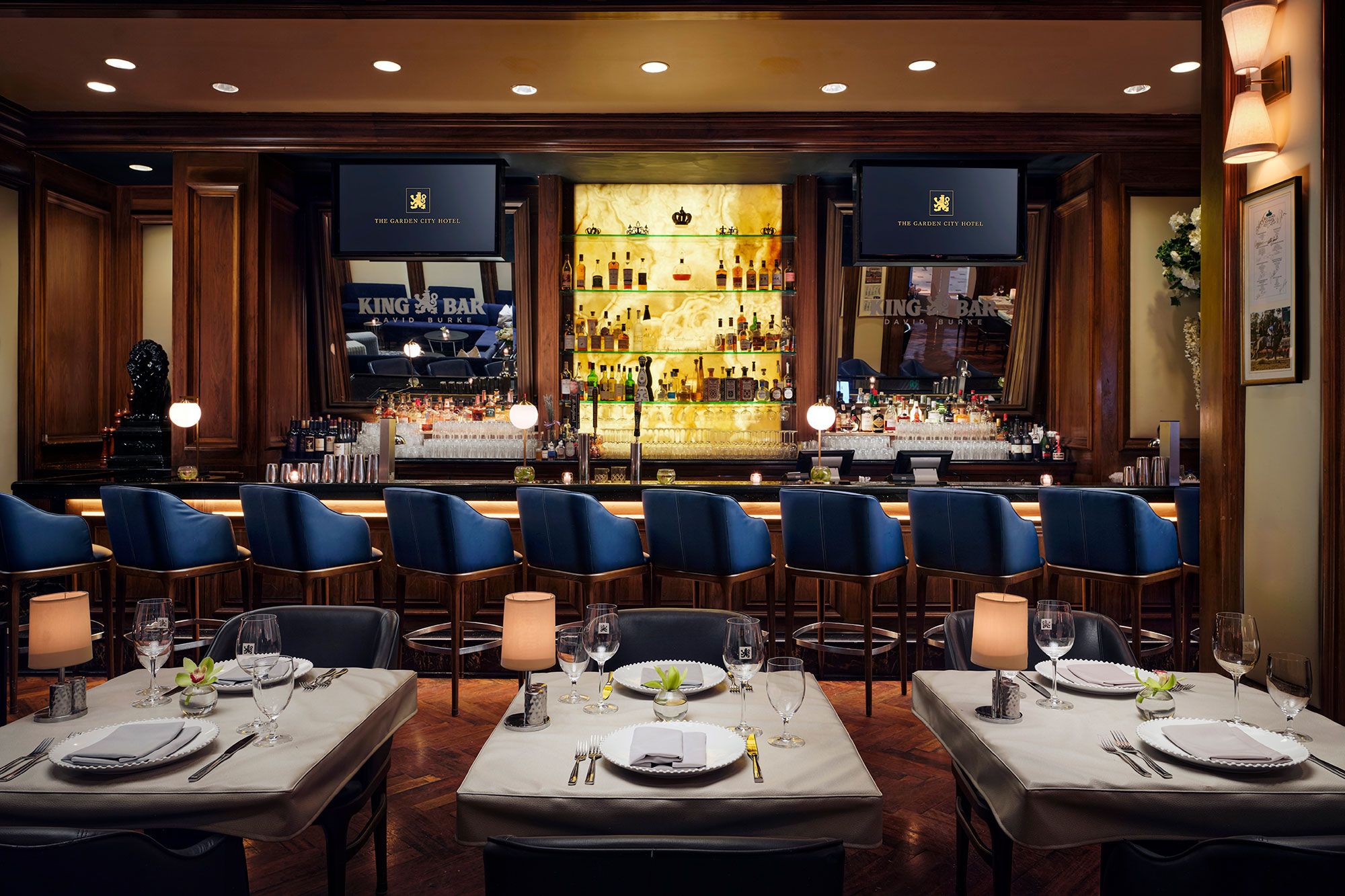 A bar area with multiple seating arrangements and a well-stocked bar counter.