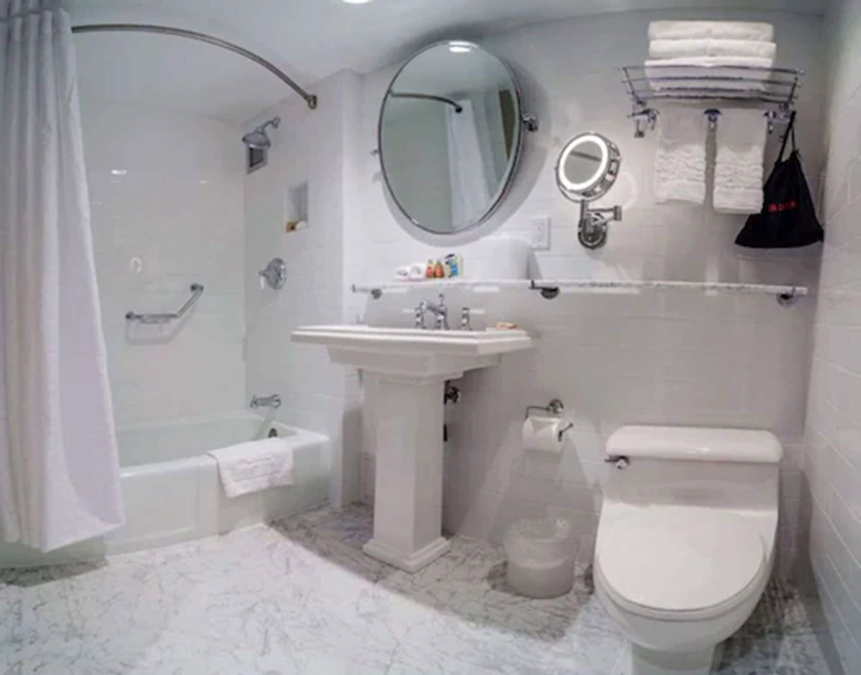 A bathroom with a bathtub, sink, toilet, and a shower area.