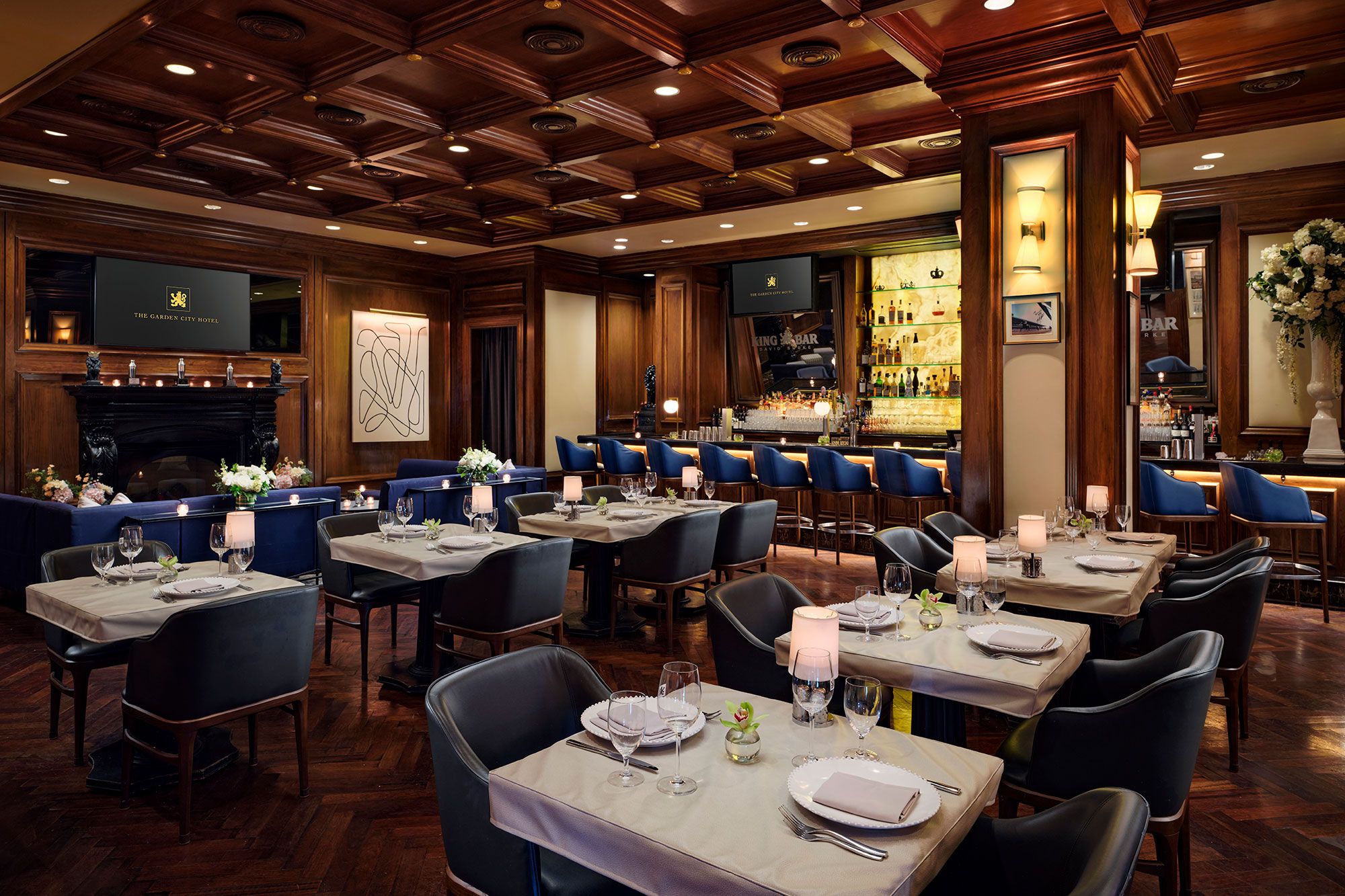 A restaurant with multiple tables, chairs, and a bar area.
