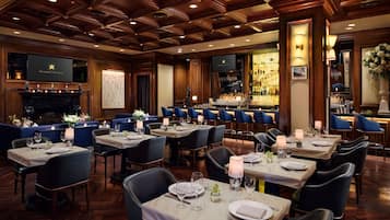 A restaurant with multiple tables, chairs, and a bar area.