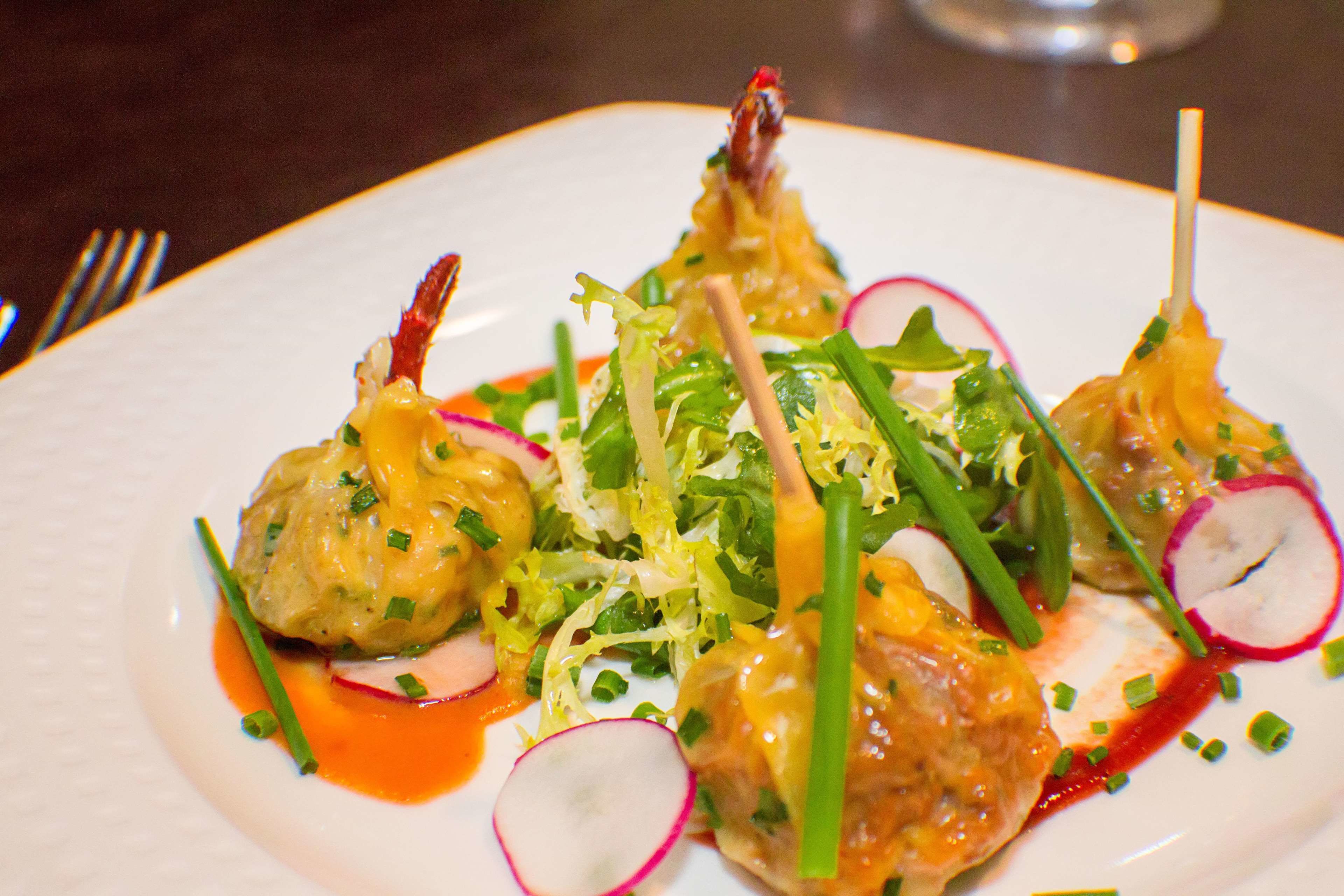 A plate of food with various garnishes and a sauce.