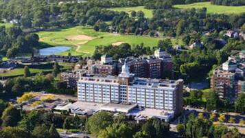 Een groot hotel met meerdere gebouwen, omringd door groen en een golfbaan.