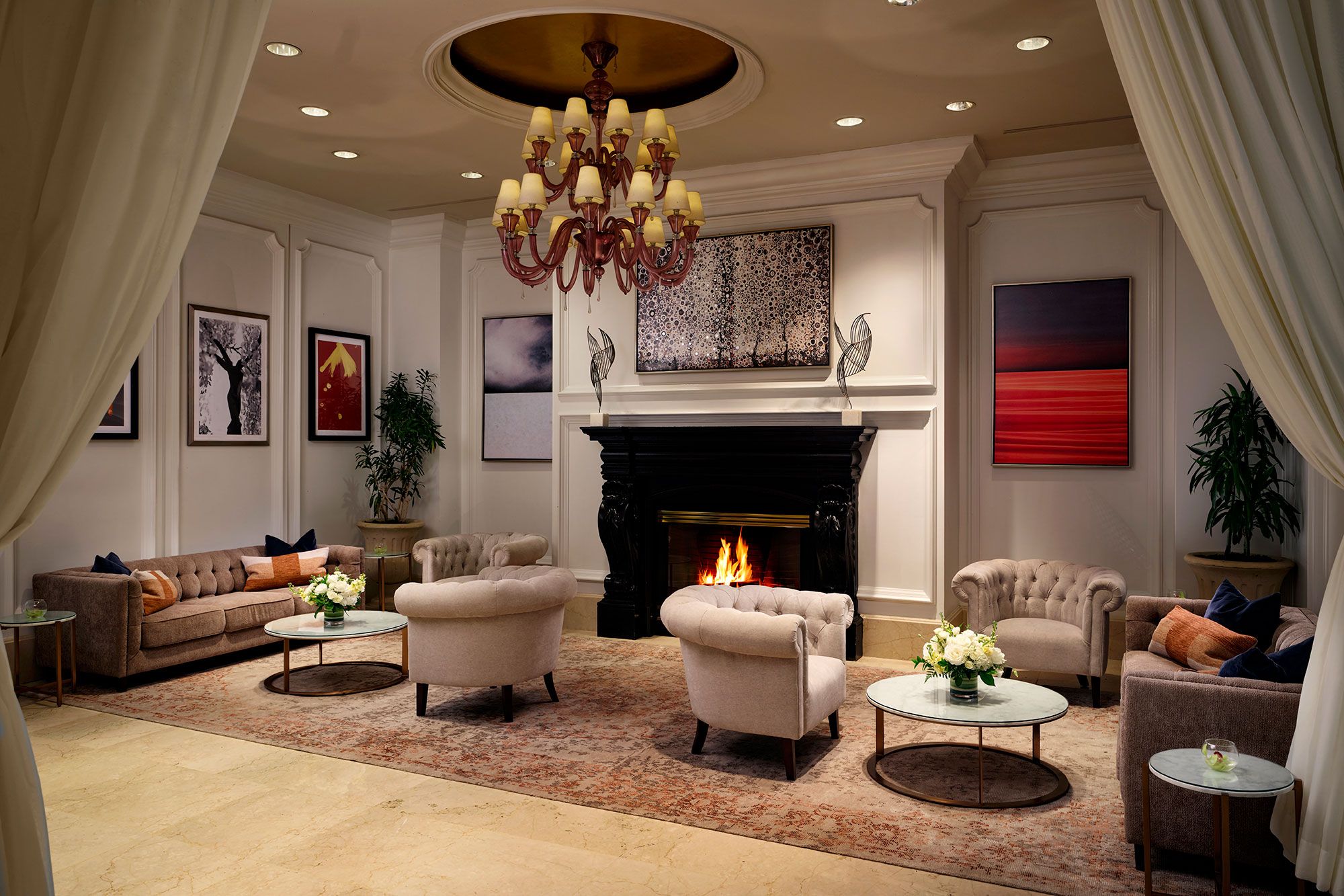 A spacious living room with a fireplace, comfortable seating, and artwork on the walls.