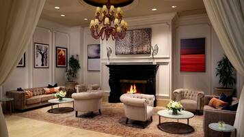 A spacious living room with a fireplace, comfortable seating, and artwork on the walls.