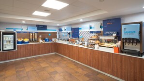 A breakfast area with a fruit display, cereal, and a bakery section.
