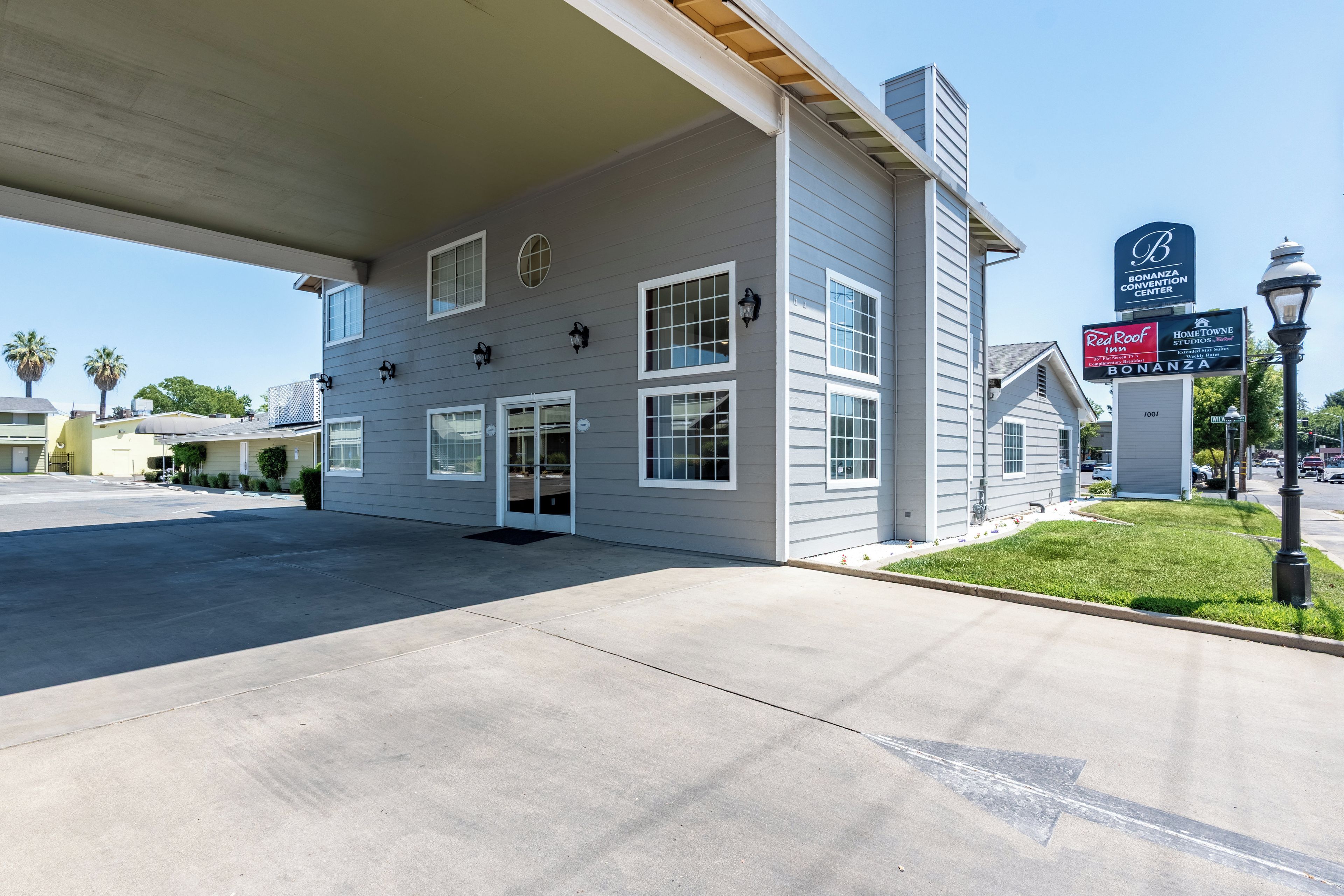 A building with a gas station sign, a Red Roof sign, and a Bonanza Convention Center sign.