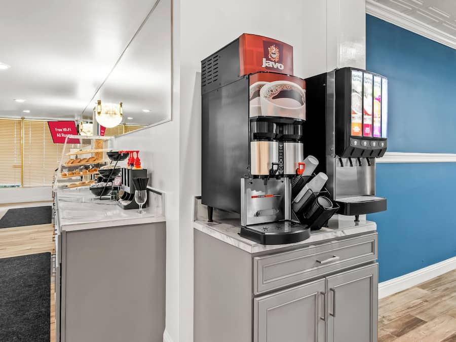 A coffee machine with a Javo branded coffee pod dispenser, a steam wand, and a milk frothing station.