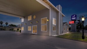 Un hôtel doté d’une grande enseigne, de nombreuses fenêtres et d’une façade bien éclairée.