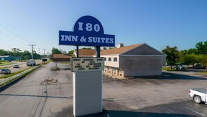 Naamplaatje voor Inn & Suites bij nummer 180, met vermelding van recent gerenoveerde kamers en tarieven voor wekelijkse en maandelijkse verhuur.