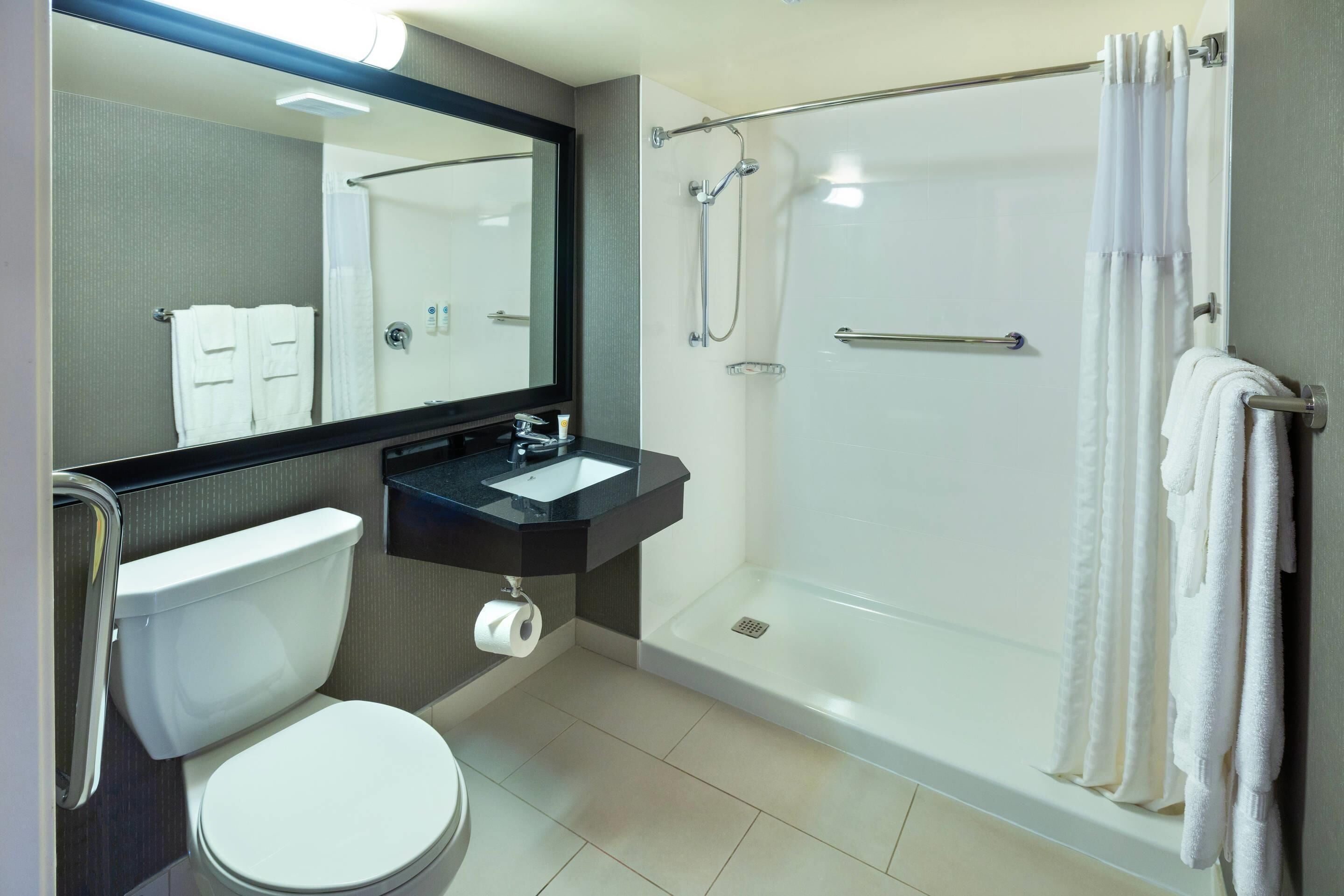 Ein modernes Badezimmer mit Toilette, Waschbecken und Dusche.