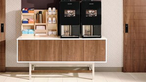 A coffee station with two coffee machines and a variety of coffee pods and accessories.