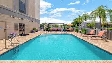 Ein Pool mit Tiefenanzeige, Liegestühlen und einer überdachten Sitzgelegenheit.