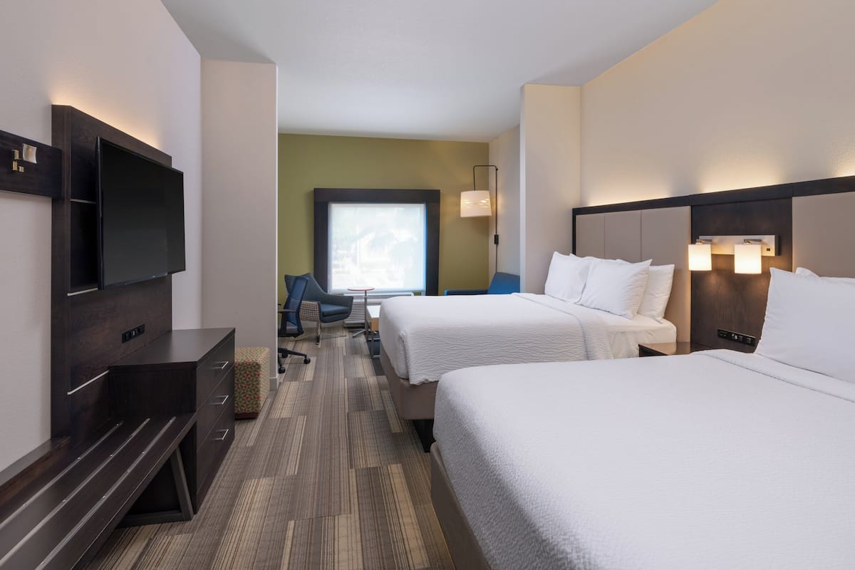Een hotelkamer met twee bedden, een flatscreen-tv, een bureau en een raam met uitzicht.