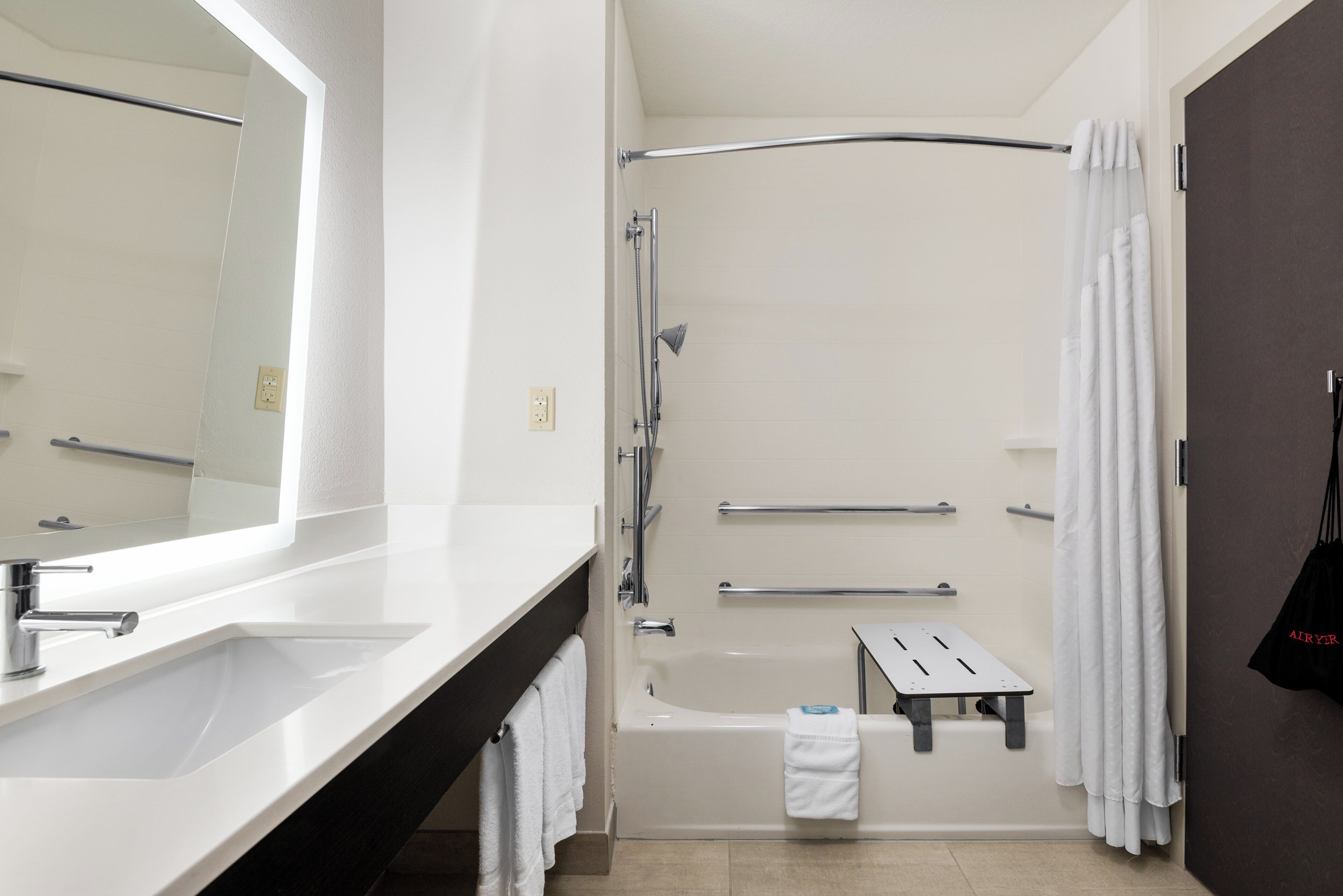 A bathroom with a bathtub, a shower, a sink, and a mirror.