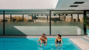 A modern indoor swimming pool with clear glass walls, a view of the cityscape, and a contemporary architectural design. - Novotel Paris Centre Tour Eiffel (Paris)