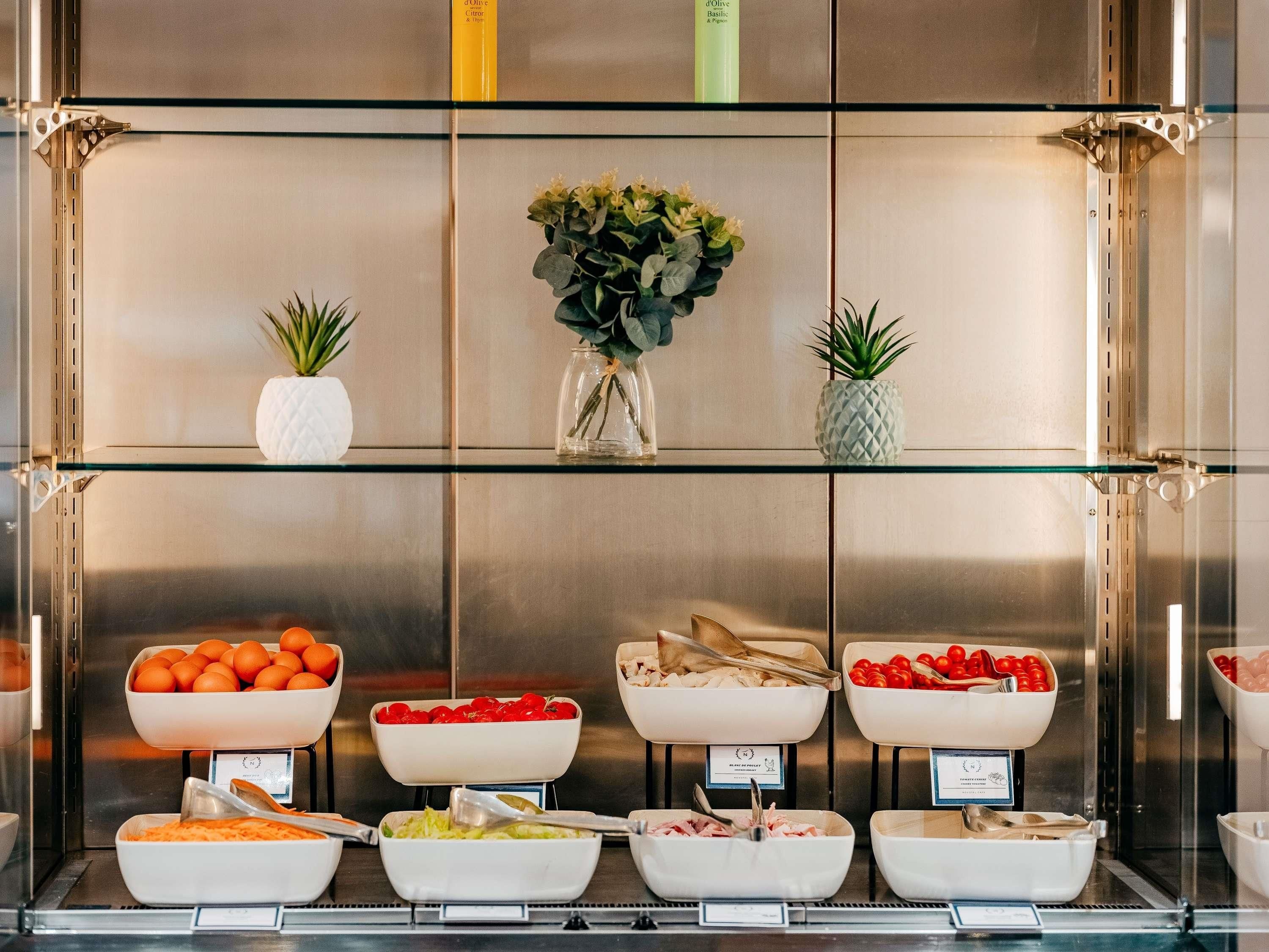 A buffet with various food items and a decorative plant arrangement.