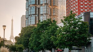 A modern urban landscape with high-rise buildings, including a distinctive red and white facade and a tower with a lattice structure. - Novotel Paris Centre Tour Eiffel (Paris)