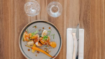 Un plato de comida con un tenedor y una servilleta sobre una mesa de madera.