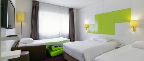 A hotel room with two beds, a desk, a chair, a television, and a window with curtains.