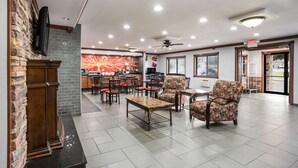 A spacious lobby with a fireplace, seating area, and a restaurant counter. - Quality Inn Cedar Rapids South (Cedar Rapids)