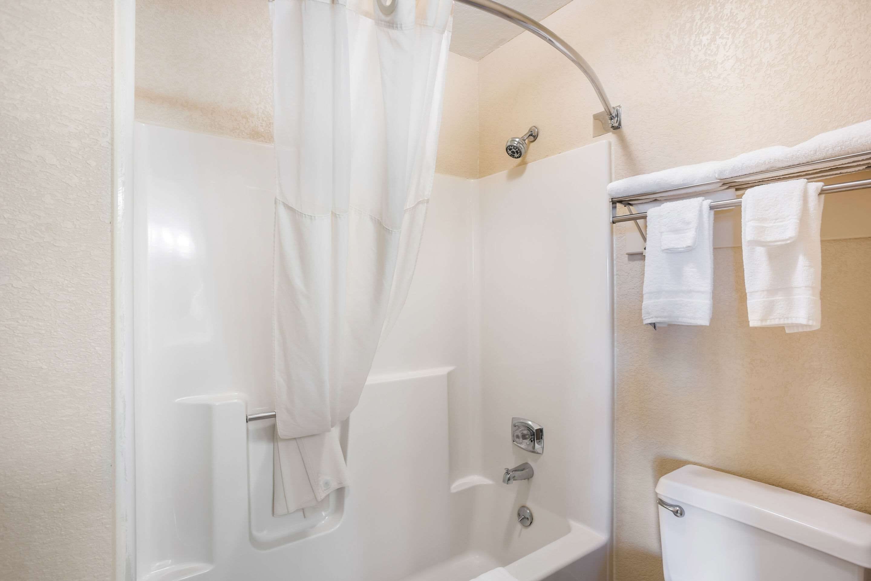 A bathroom with a bathtub, shower, and toilet.