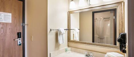 A bathroom with a sink, mirror, towel rack, and a hairdryer.