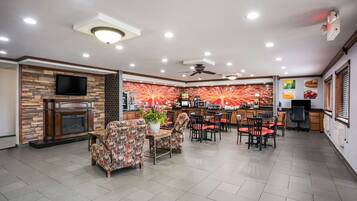 A spacious living area with a fireplace, comfortable seating, a kitchen area, and a dining space.