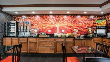 A restaurant with a central counter, wooden cabinets, and red cushioned chairs.