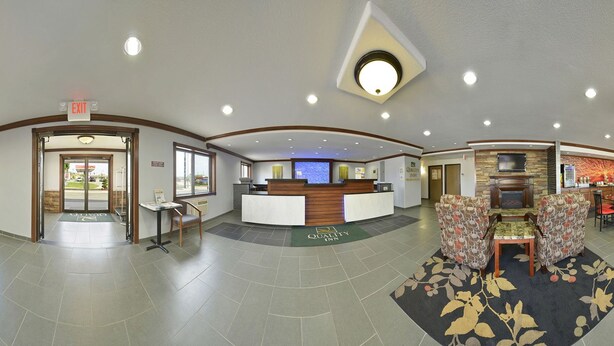 A hotel lobby with a reception desk, seating area, and a fireplace. - Quality Inn Cedar Rapids South (Cedar Rapids)