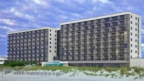 A modern hotel with a grid-like facade, multiple floors, and a flat roof.