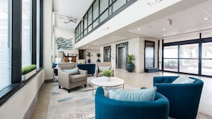 A spacious lobby with high ceilings, large windows, and a reception desk.