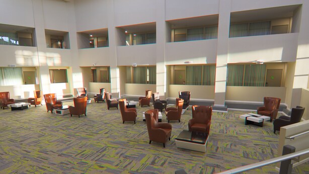 A spacious lobby with multiple seating areas, large windows, and a patterned carpet.