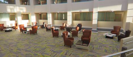 A spacious lobby with multiple seating areas, large windows, and a patterned carpet.