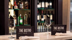 A bar area with wine glasses and a sign reading "THE BISTRO" with the tagline "EAT. DRINK. CONNECT."