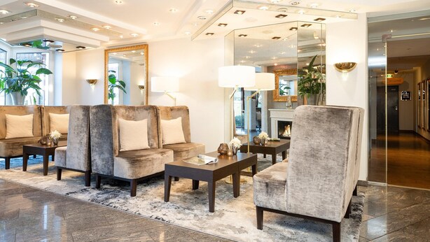 A modern lobby with a seating area, a fireplace, and a large mirror reflecting the room. - Best Western Victor's Residenz-Hotel Rodenhof (Saarbrücken)