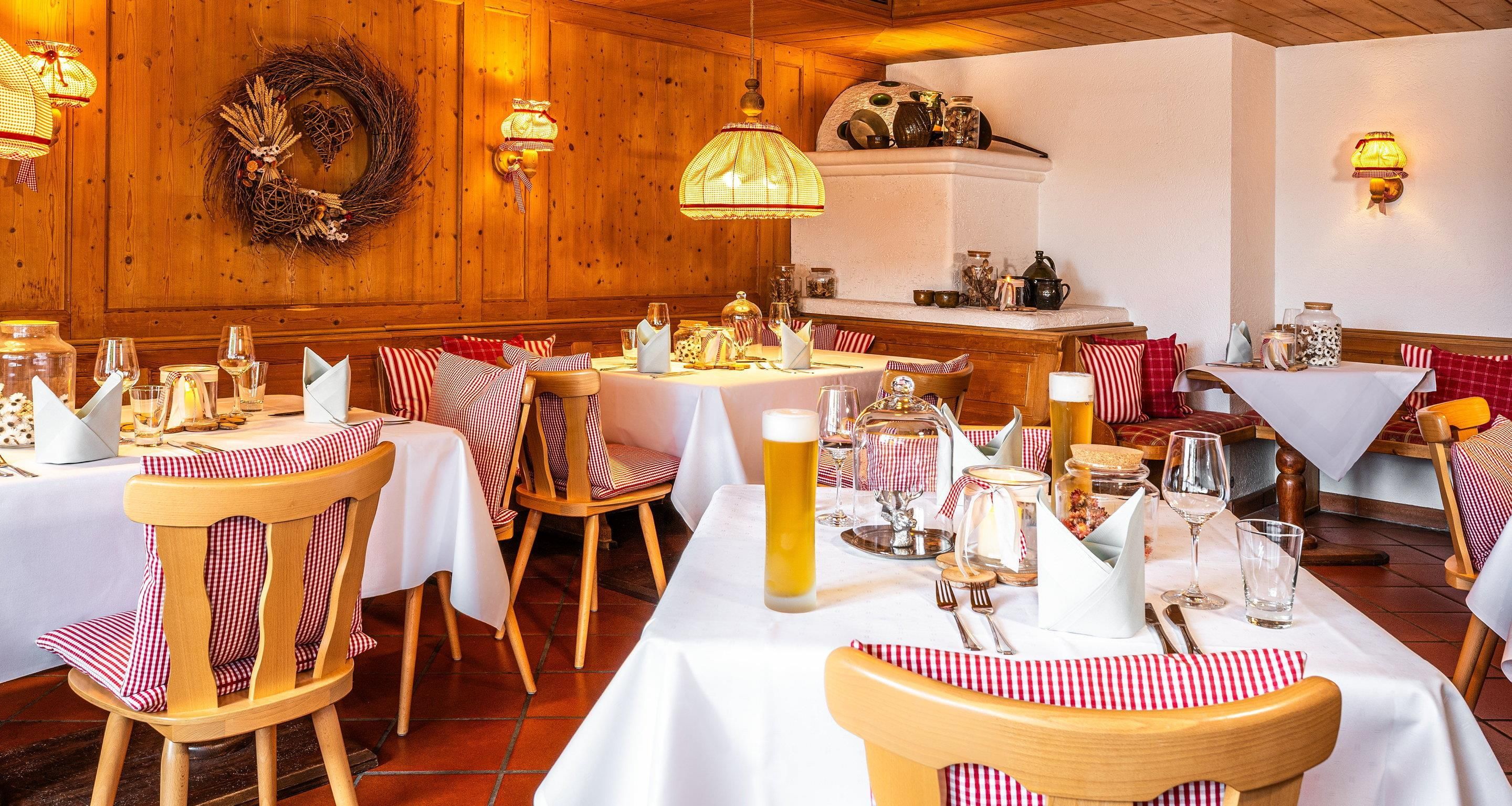 Een restaurant met houten wanden, witte tafels en stoelen met een rood-wit geruit patroon.