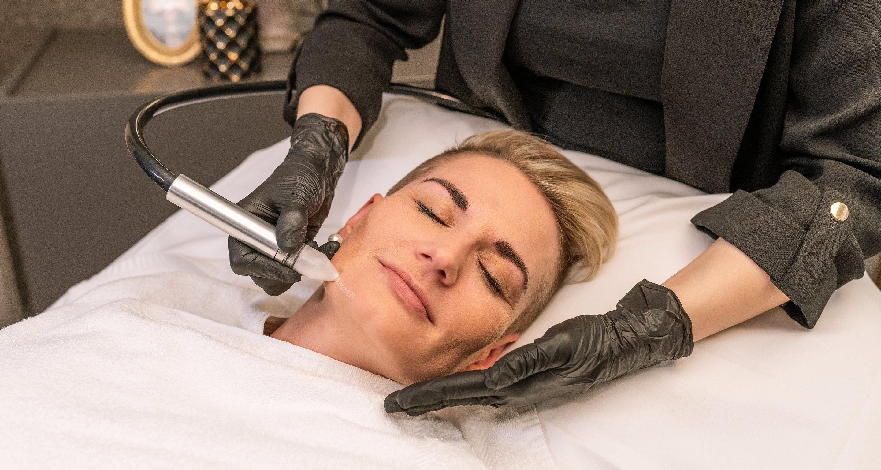 Una persona acostada con un dispositivo en el rostro, posiblemente para un tratamiento médico o de belleza.