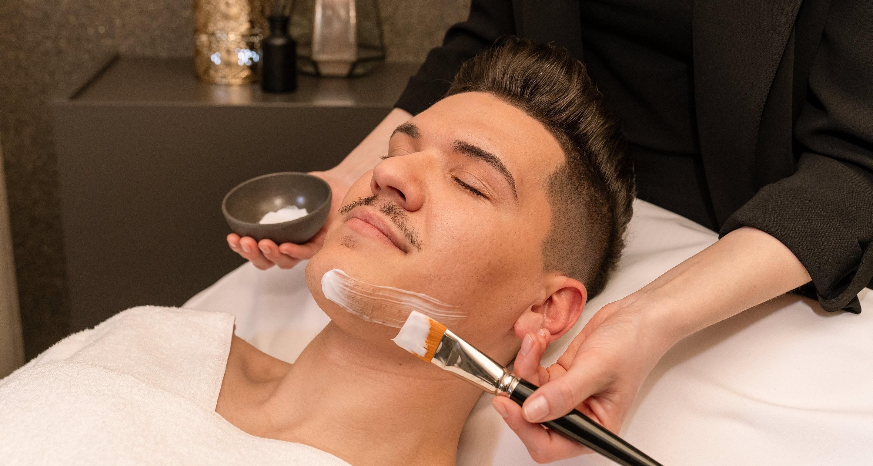 Una persona acostada recibiendo un tratamiento facial.
