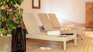 A room with a wicker sofa, a potted plant, a black metal screen, and a tiled floor. - Best Western Victor's Residenz-Hotel Rodenhof (Saarbrücken)
