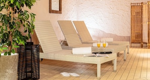A room with a wicker sofa, a potted plant, a black metal screen, and a tiled floor. - Best Western Victor's Residenz-Hotel Rodenhof (Saarbrücken)