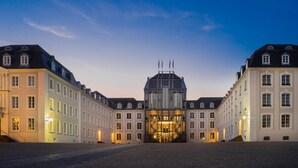 A historic building with symmetrical architecture, a central glass facade, and a cobblestone courtyard. - Best Western Victor's Residenz-Hotel Rodenhof (Saarbrücken)