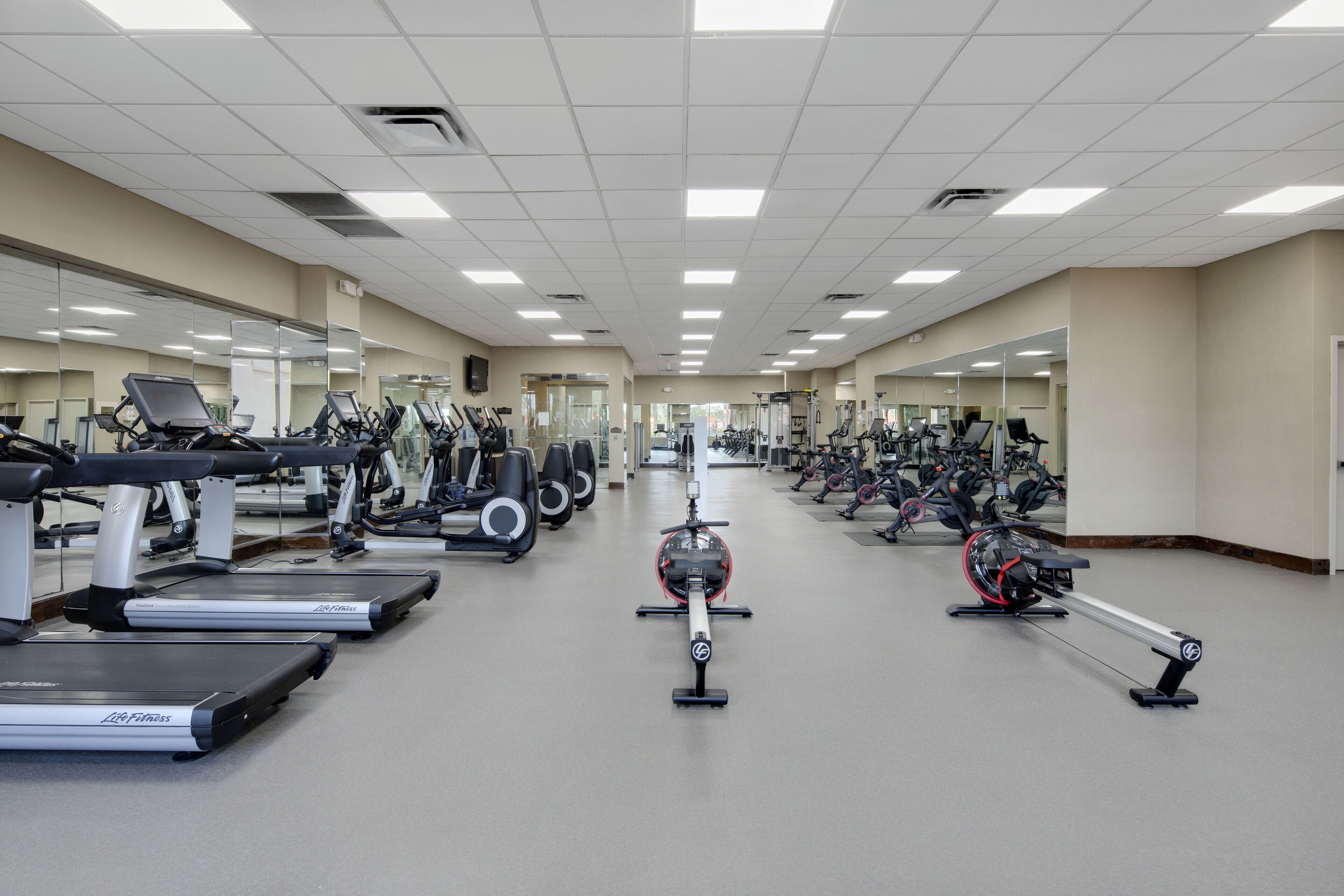 A gym with multiple treadmills, stationary bikes, and weight machines.