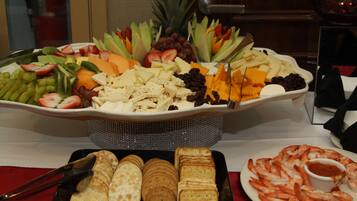 Un buffet proposant une variété de fruits, de fromages et de crevettes.