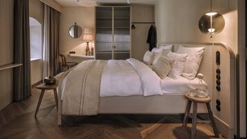 A modern bedroom with a large bed, a bedside table, a lamp, and a wardrobe.