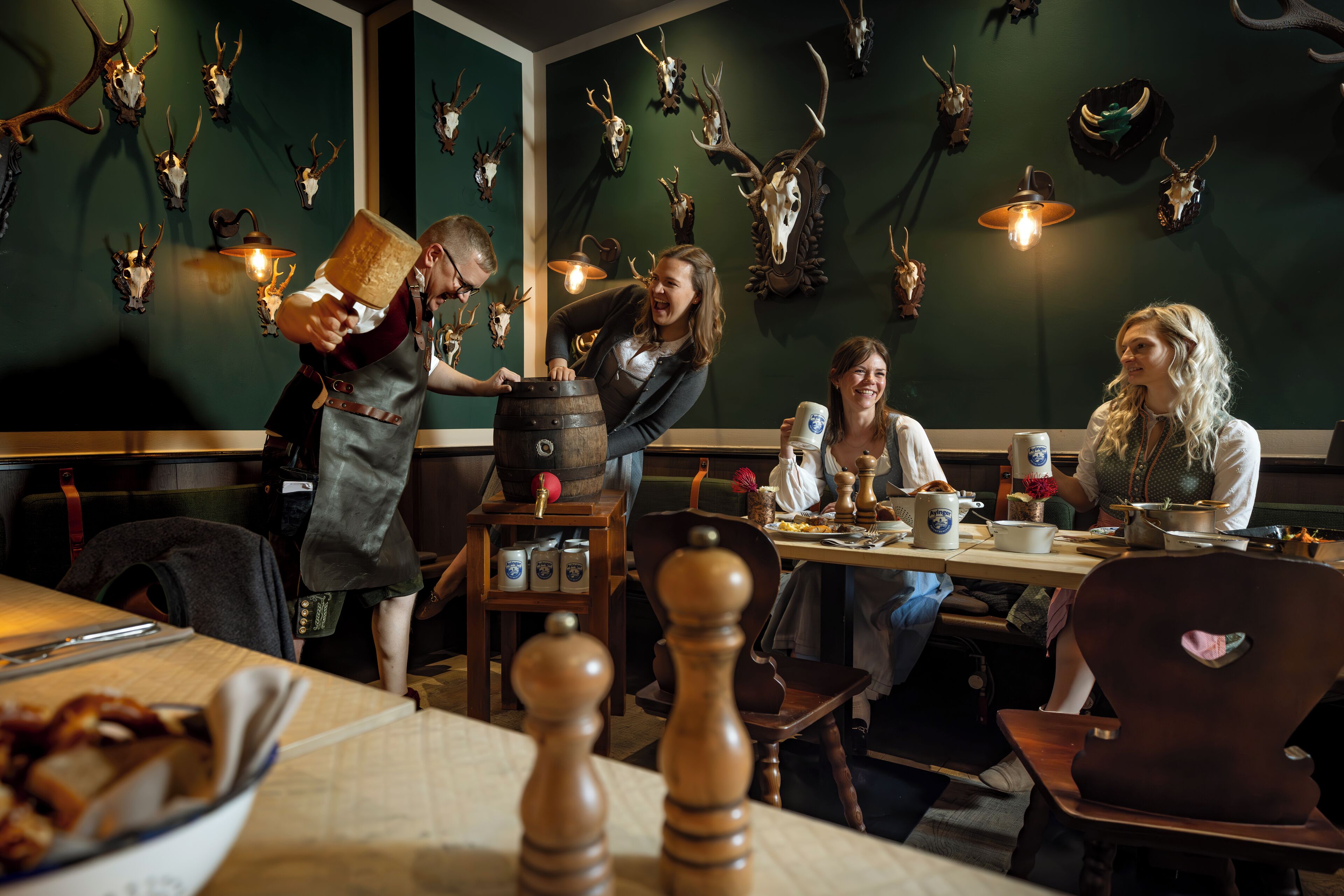 Un restaurante con decoración rústica, que presenta cráneos de ciervo en la pared y mobiliario de madera.