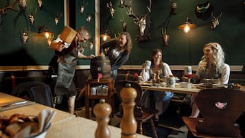 Un restaurante con decoración rústica, que presenta cráneos de ciervo en la pared y mobiliario de madera.