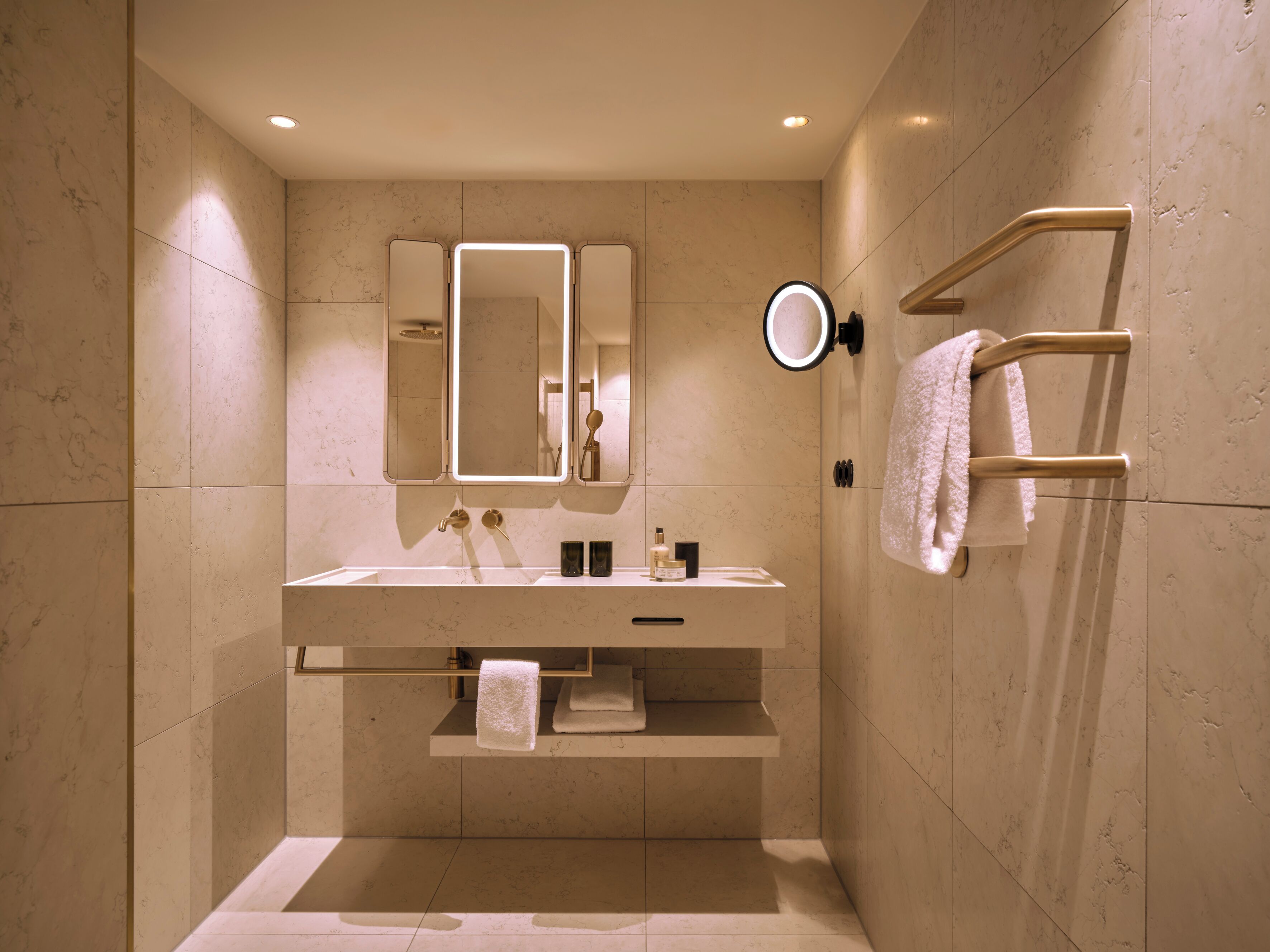 Un baño moderno con un espejo grande, un lavamanos y un perchero para toallas.