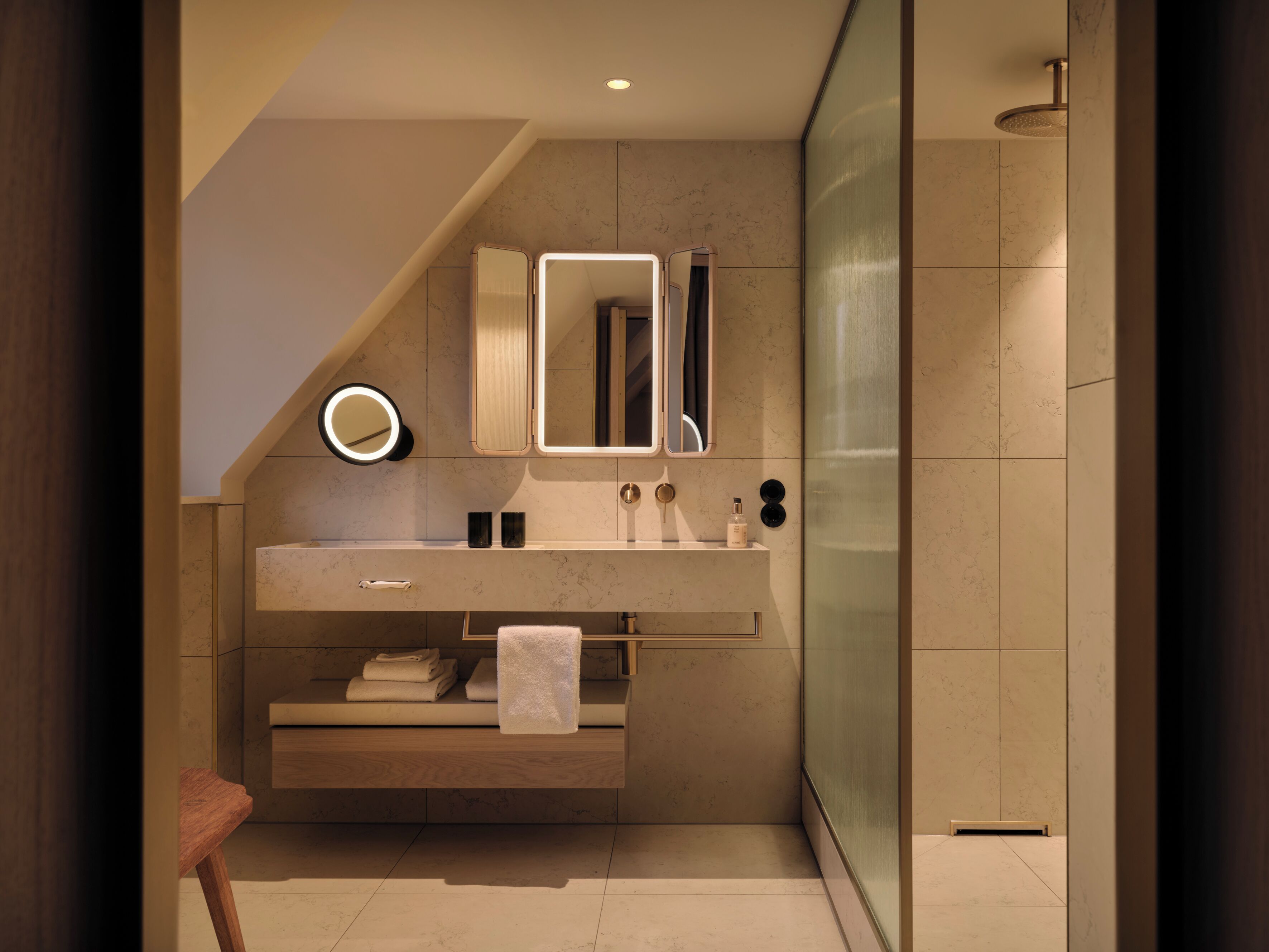 Un baño moderno con tocador, espejo, toallero y ducha.